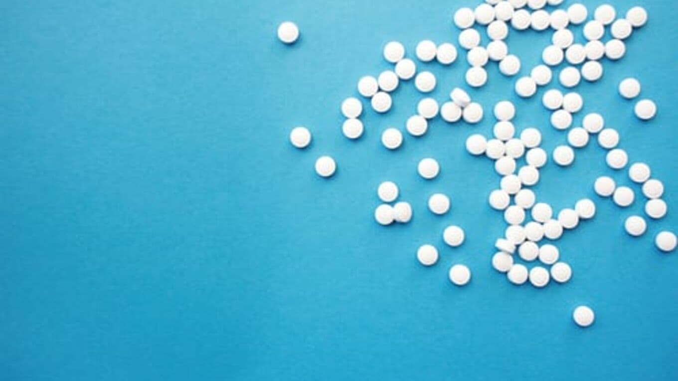 White pills on a light blue background